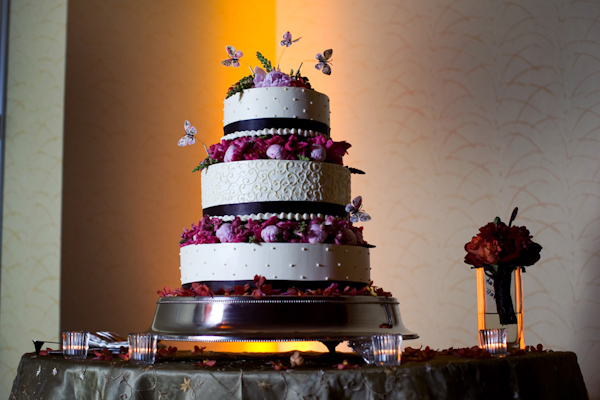 Three tiered white and purple wedding cake with butterflies - photo by Melissa Jill Photography